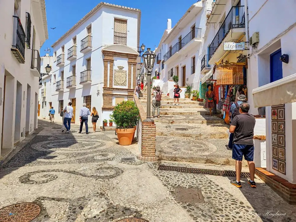Pedestrians on a whitewashed street in Spain