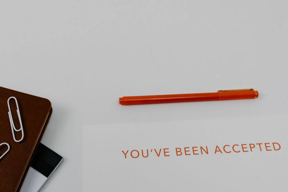 Acceptance letter, pen and notebook on a desk