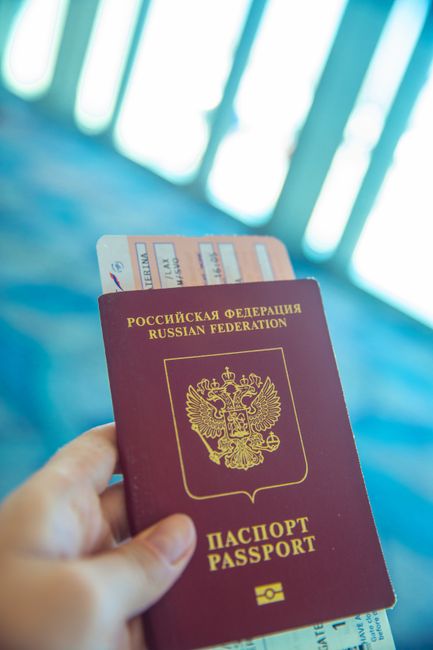 Passport and visa documents beside a phone showing a calendar reminder