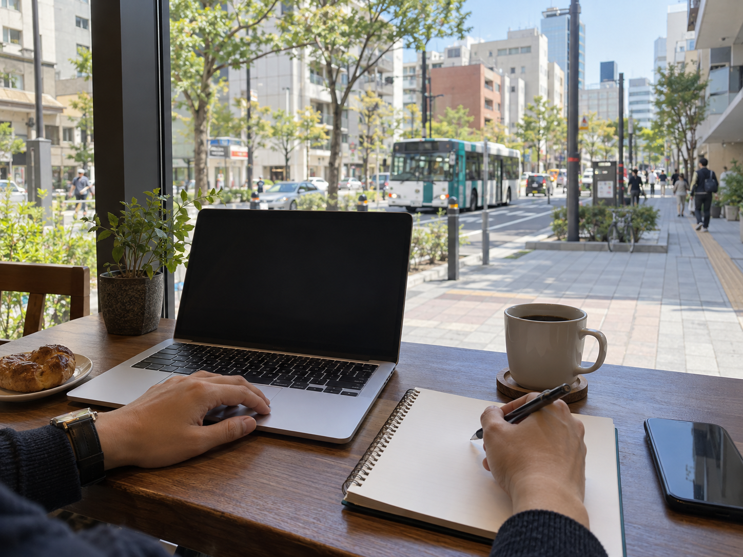 Person planning a weekly routine beside a laptop in a city café