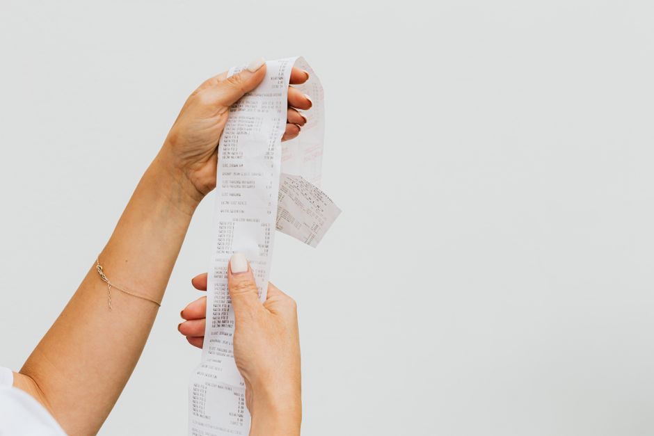 Person checking a detailed shopping receipt