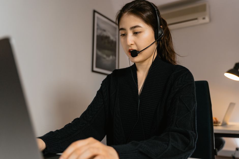 Remote worker using a laptop and headset at a desk