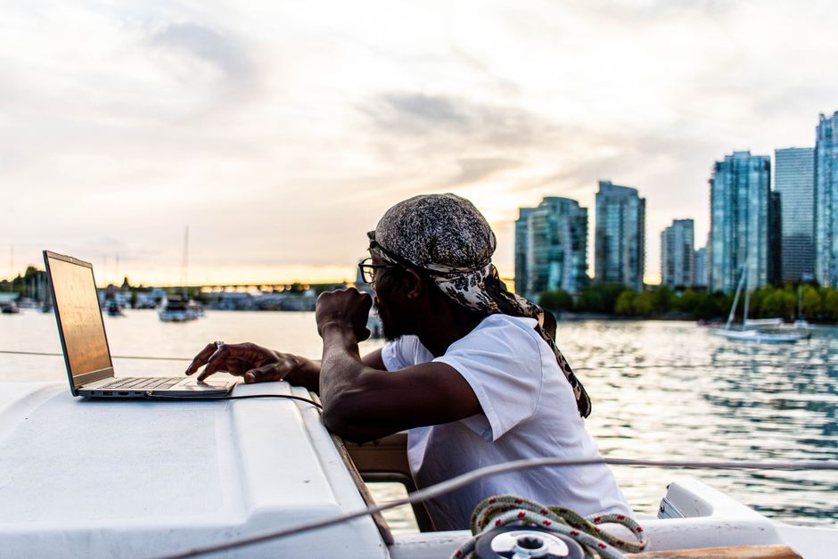 Person using a laptop with the Vancouver skyline behind them